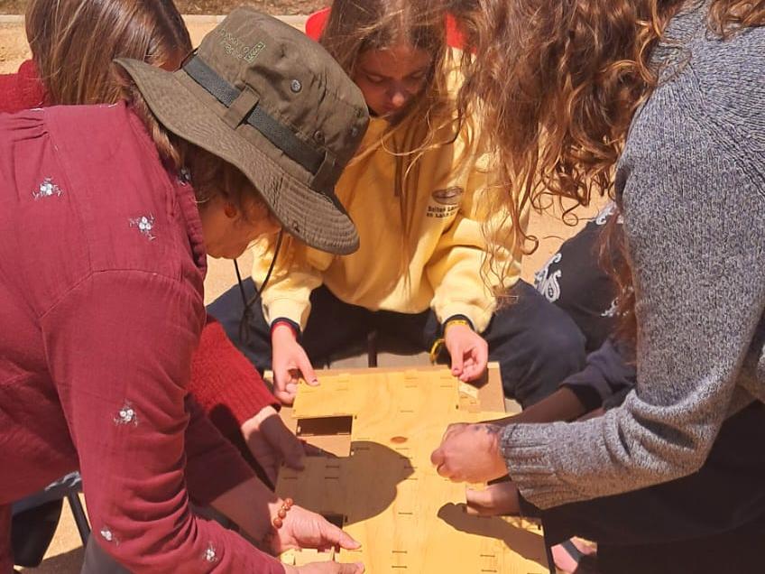Actividad con estudiantes de cuarto medio del Colegio Waldorf Viento Sur. Con ellas se realiza actividad de armado de los modelos de la cabaña. Por del Villar C.R.(5-noviembre 2024). Archivo CMCP.