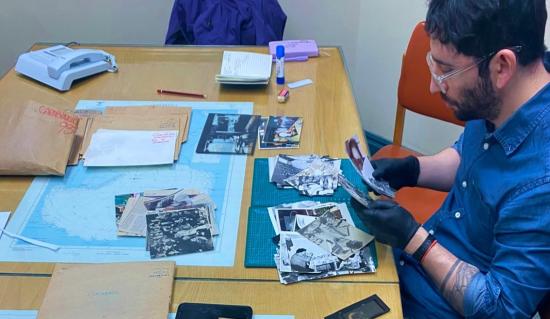 Imagen de Proyecto “Archivo fotográfico La Prensa Austral: patrimonio documental de Magallanes”  Personas en escritorio seleccionando fotos